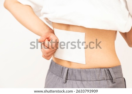 A woman's lower back with a compress applied.