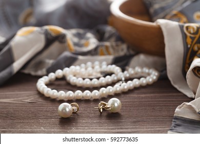 Womans morning scene with pearl lay on silk shawl