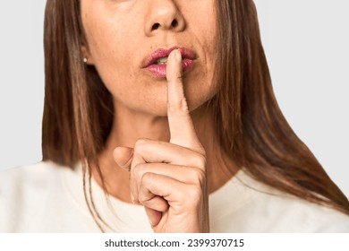 Woman's mouth in silence gesture in studio - Powered by Shutterstock