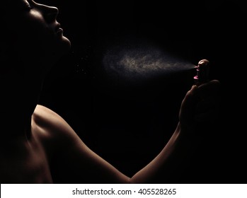 Woman's perfume in the hand on black background 