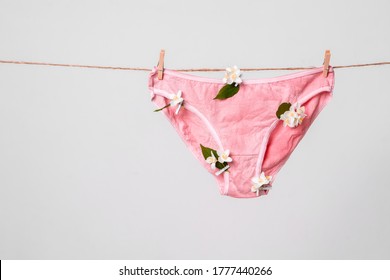 Woman's pink underwear with flowers on clothesline, concept content for feminist blog, poster about women's health