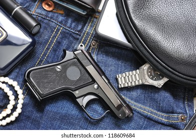 A Woman's Purse And  Gun And Accessories