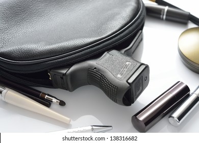 A Woman's Purse And Gun And Accessories