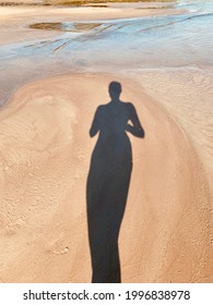 Woman's Shadow On The Sand On The Beach