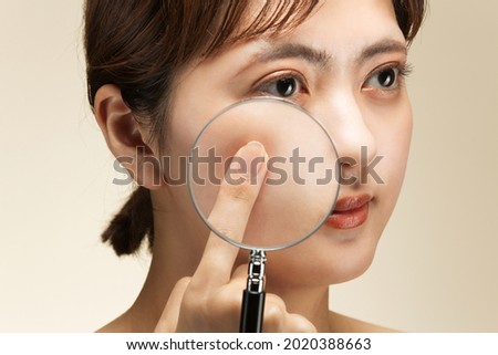 The woman's skin is enlarged with a loupe.