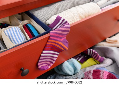Woman's Sock And Pile Of Clothes In Open Drawer, Close Up