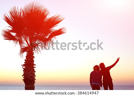  woman's stands on the embankment and prepares for jogging on the beach against sunrise sky