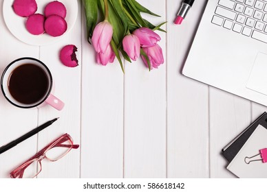 Woman's work place top view. Computer, glasses, coffee and accessories in pink color on white wooden table. - Powered by Shutterstock