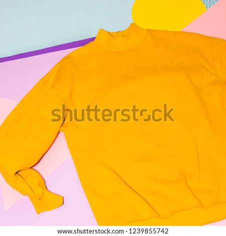 Woman's yellow pullover on memphis style background. Geometry minimal concept. Fall and winter fashion. 
