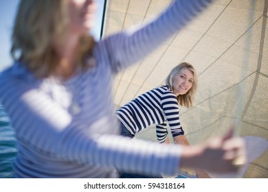 Women Adjusting Sails On Boat