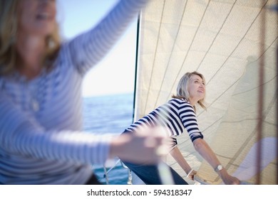 Women Adjusting Sails On Boat