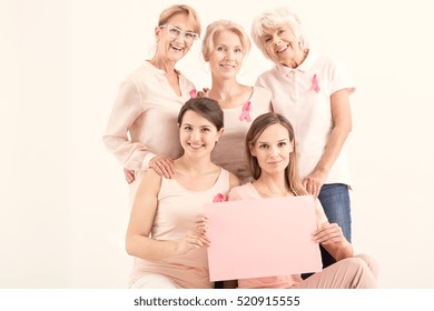 Women against cancer holding pink paper card - Shutterstock ID 520915555