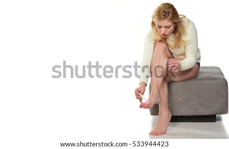 women applying nail polish on her toes