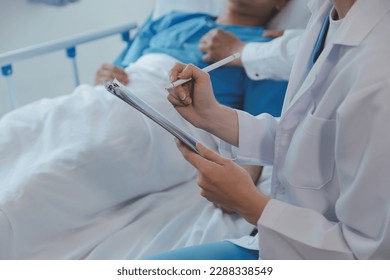Women Asian doctors hold the patient hand and encourage and provide medical advice While checking the patient health in bed. Concept of Care and compassion, antenatal care, Threatened abortion - Powered by Shutterstock