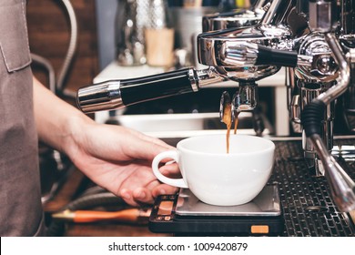 Women Barista using coffee machine for making coffee in the cafe