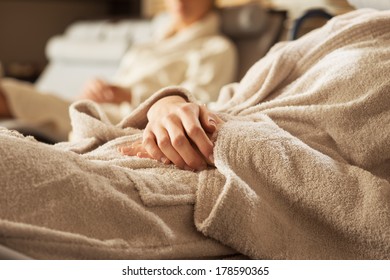 Women in bathrobe relaxing at spa, lying on a sofa. - Powered by Shutterstock