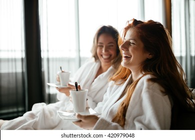 Women in bathrobes enjoying tea during wellness weekend - Powered by Shutterstock