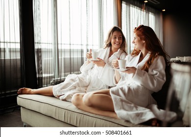 Women in bathrobes enjoying tea during wellness weekend - Powered by Shutterstock