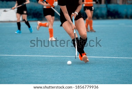 Women battle for control of ball during field hockey game. Sport team concept. Vintage color filter