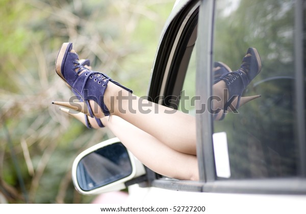 Women\
beautiful legs in high heel shoes, car\
window