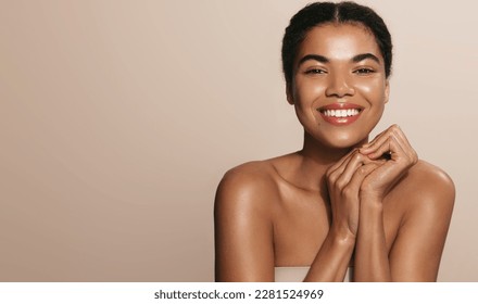 Women beauty and health. Young smiling african american girl, laughing and smiling, posing with glowing, clean and clear skin without blemishes, healthy facial glow after moisturizer, nourishing gel. - Powered by Shutterstock