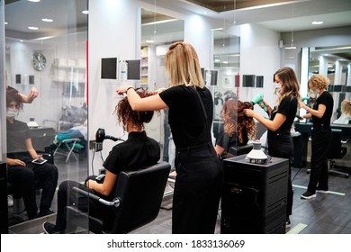 women in a beauty salon with social distance and protective masks - new normal - Shutterstock ID 1833136069