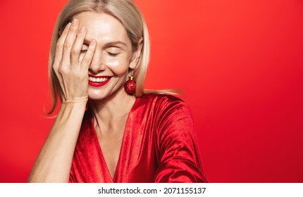 Women Beauty And Winter Holidays Concept. Happy Smiling Middle Aged Woman, 50 Years Old, Laughing Sensual, Posing In Red Dress, Makeup And Christmas Bubble Earrings