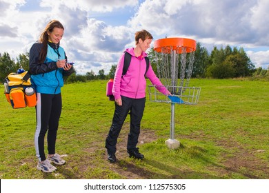 Women Beside The Basket During The Disc Golf Game