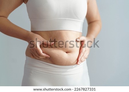 Women body fat belly. Obese woman hand holding excessive belly fat. diet lifestyle concept to reduce belly and shape up healthy stomach muscle. Imagine de stoc © 