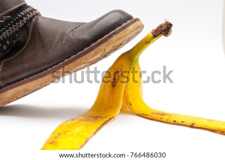 Women in brown leather shoe stepping on banana peel, isolated on white background.