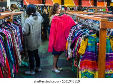 Women Browsing Through Vintage Clothing In A Thrift Store.