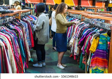 Women Browsing Through Vintage Clothing In A Thrift Store.