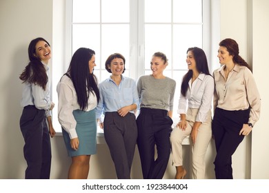 Women Business Team, Successful Communication, Office Workers. Cheerful Women Business Partners Coworkers Colleagues Having Break Of Project Discussion In Office At Window Together