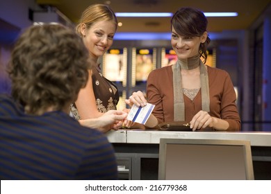 Women Buying Movie Tickets At The Box Office.