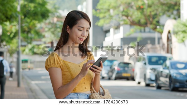 Women call taxi on\
cellphone on the street