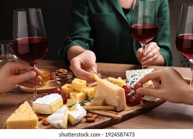 Women With Cheese Plate And Glasses Of Wine At Wooden Table, Closeup