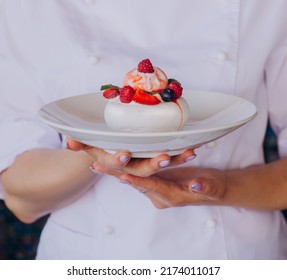 Women Chef Holding Pavlova Dessert With Strawberries On White Plate