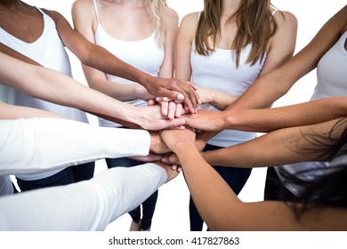 Women in a circle putting their hands together on white background