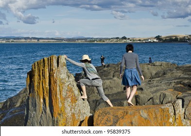 Women Climbing On Rocks, Devonport, Tasmania, Australia