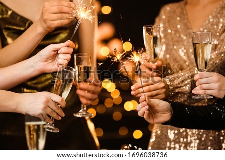 Women clinking glasses of tasty champagne at party
