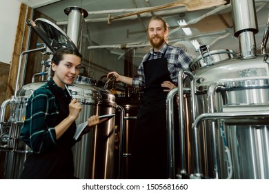 Women with clipboard working at brewery or beer plant. Brewery worker opening a lid of a beer cask at a craft beer brewery. Small business concept. - Powered by Shutterstock