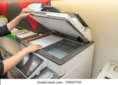 Women copying paper from Photocopier with access control for scanning key card