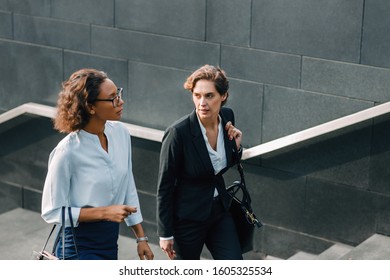 Women Coworkers Stepping Up On The Stairs And Talking