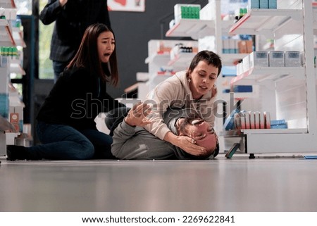 Women crying and screaming for help during person epileptic seizure in medical shop. Young man falling on floor in drugstore, having epilepsy disorder clonic stage symptoms Stock photo © 