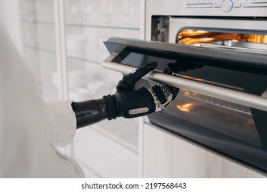 Women With Disability Holding Electric Ovens Door By Bionic Prosthetic Arm. Person With Disability Opening Or Closing Oven With Artificial Hand, Preparing Dinner, Cooking Meals Using Kitchen Appliance