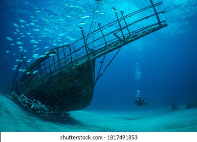 Women diver explores the wrecks at the Bridge dive site on the island of Sint Maarten, Dutch Caribbean - Shutterstock ID 1817491853