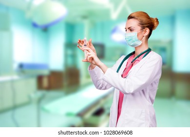 women doctor focused using an syring, preparing for an injection, operating room in background  - Powered by Shutterstock