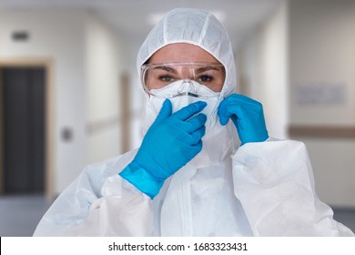 Women doctor wearing  protective suit to fight coronavirus pandemic covid-2019. Protective suit, googles, gloves, respirator.