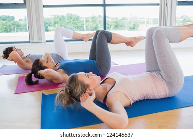 Women Doing Core Exercise On Mats In Fitness Studio