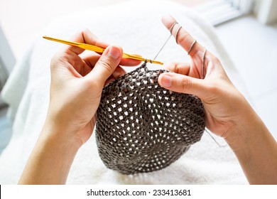 A Women Is Doing A Crochet Hat.